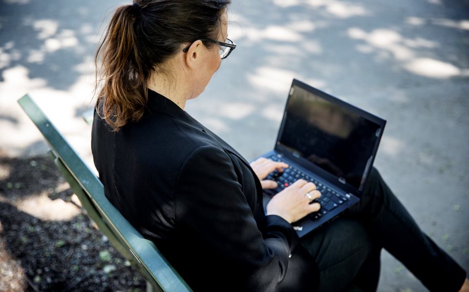 Women with laptop sitting on a bench