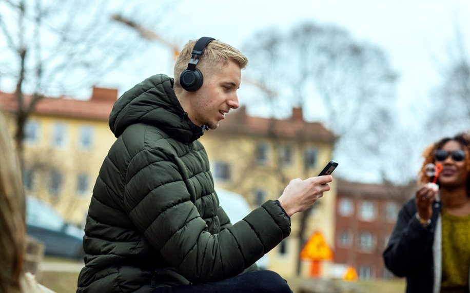 Vad är streaming Man utomhus med hörlurar och mobiltelefon.