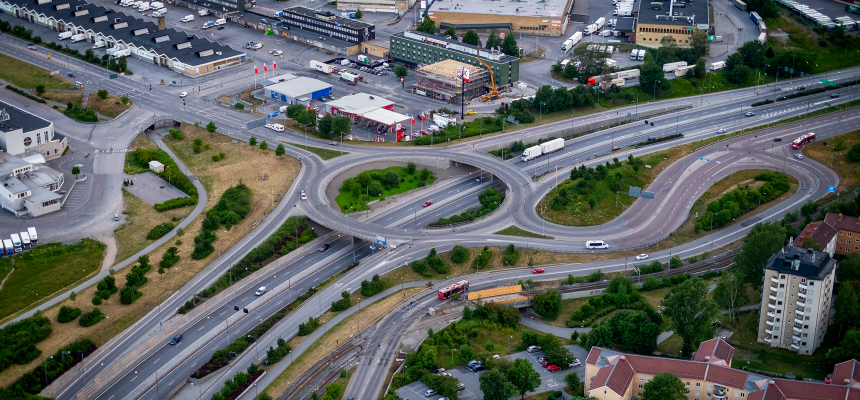 Flygbild av motorväg och samhälle.